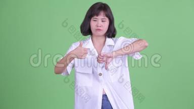 困惑的亚洲女商人在<strong>竖</strong>起大拇指和<strong>竖</strong>起大拇指之间做出选择